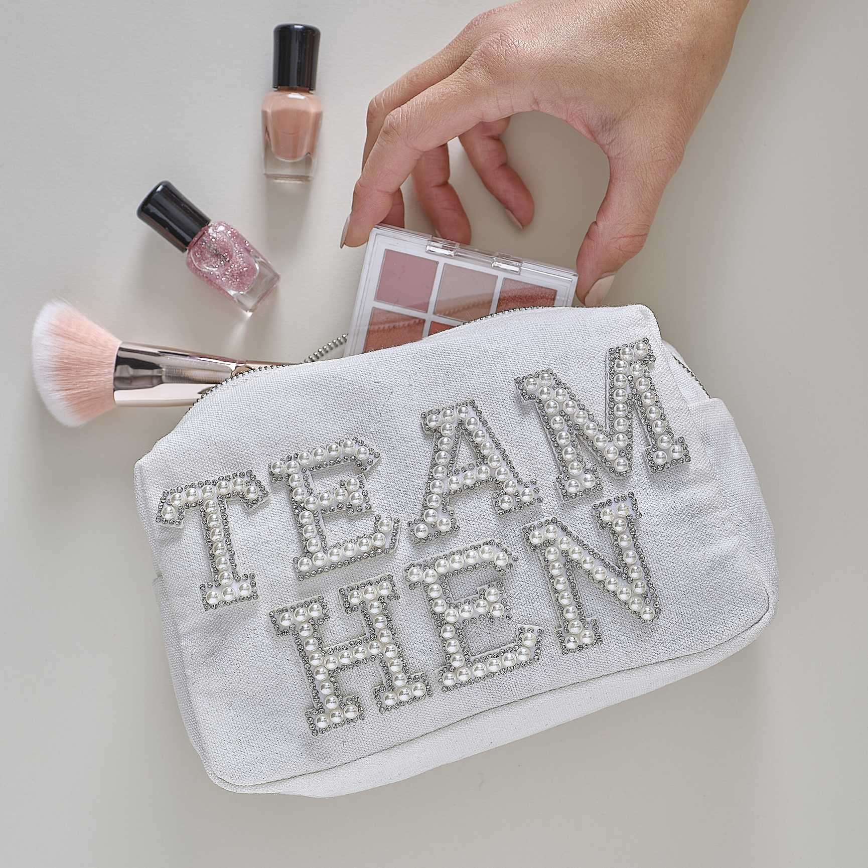 white pearl-embellished “Team Hen” makeup bag for hen party